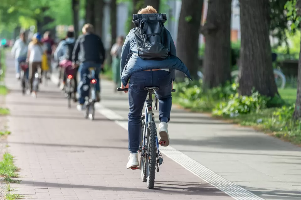 People riding bikes on a paved bike trail.